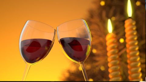 Two wine glasses clinking in a toast with red wine