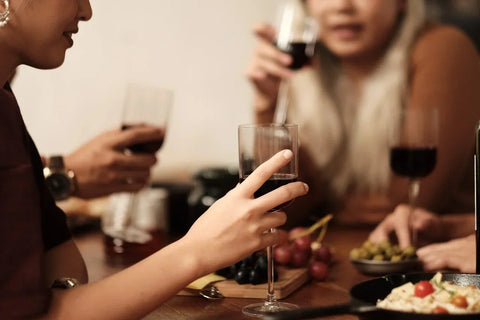 Friends enjoy red wine and small bites from Community Wine & Spirits.
