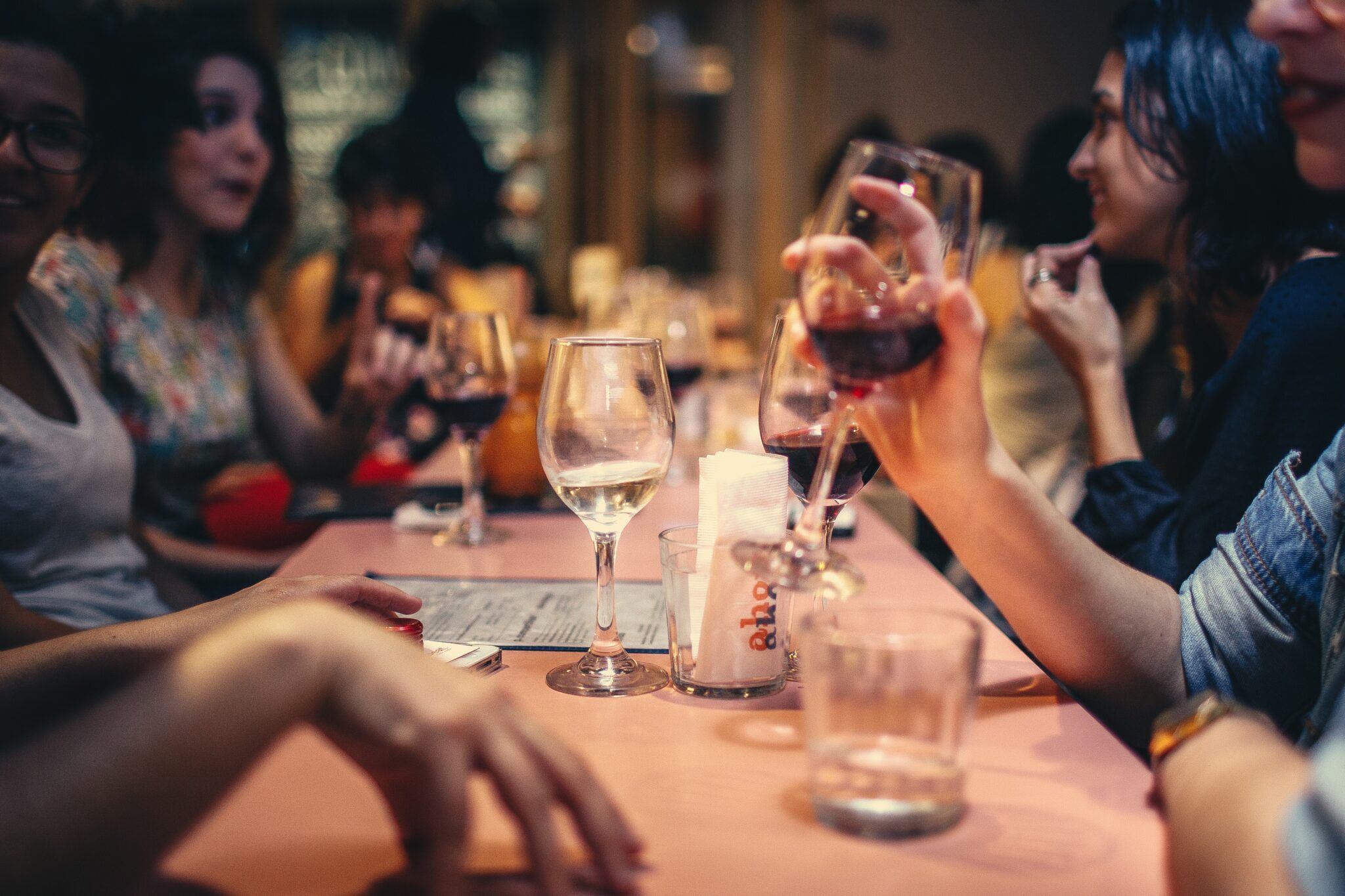 Women drinking wine at a table talking